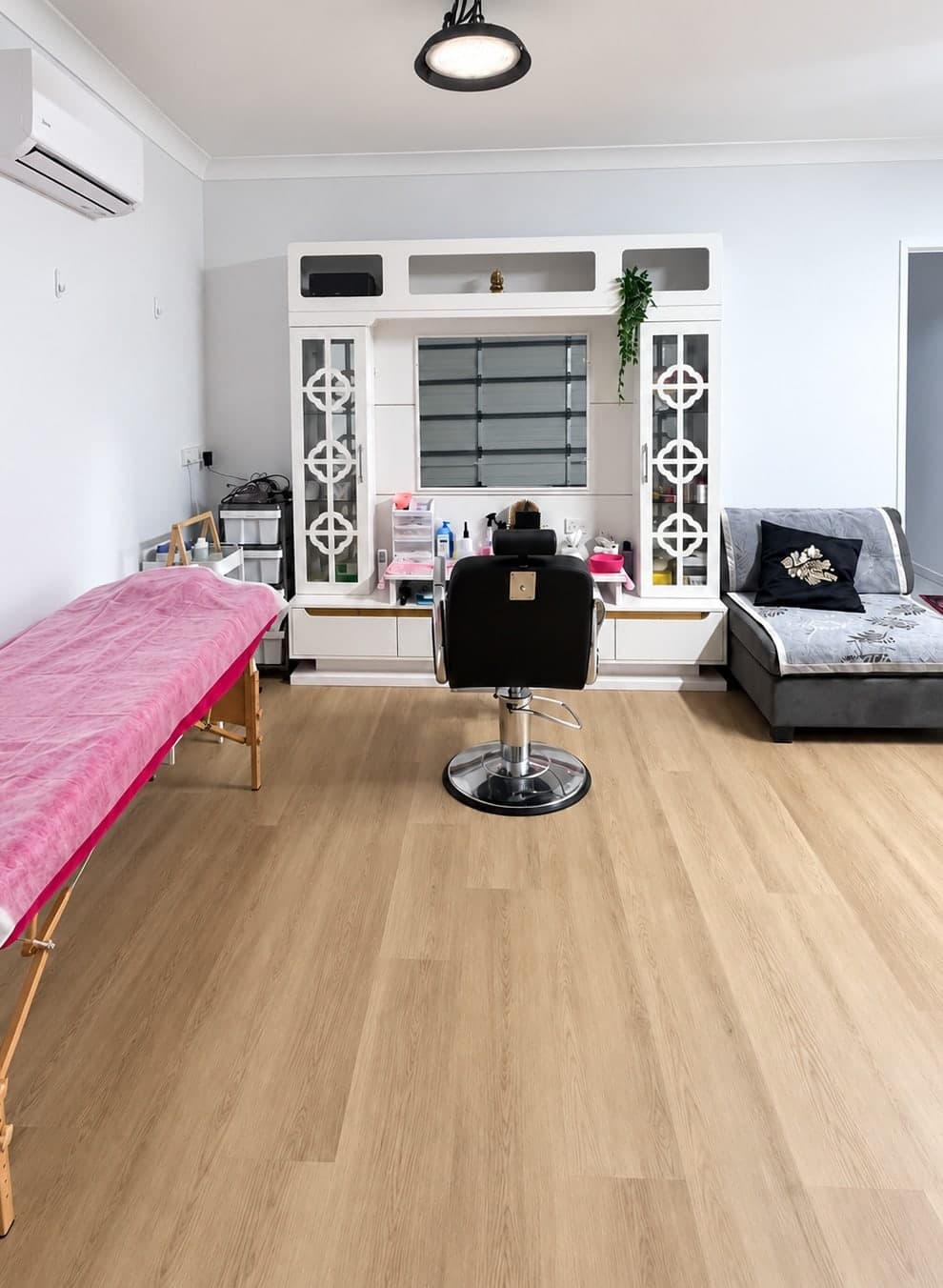 The treatment room at Enrich Beauty Salon, with a massage bed, styling chair and vanity