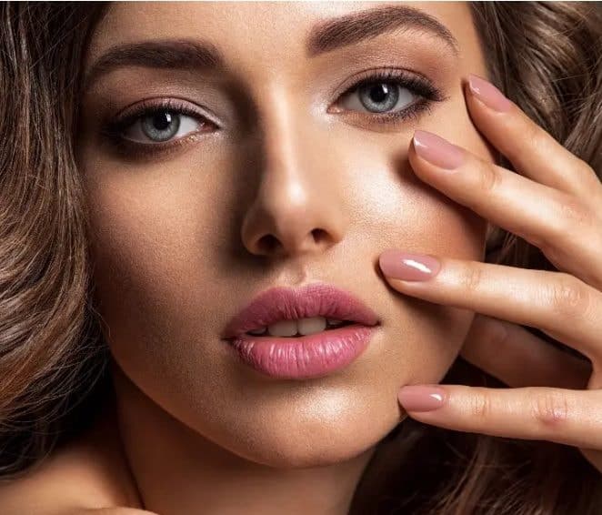 Woman with glowing skin and soft pink makeup